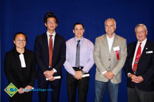 Scholarship recipients with two men in suits.