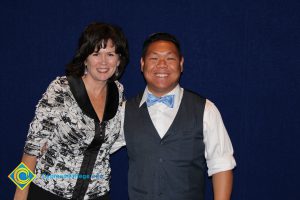 Lynn Mitts with a young man in a white shirt, blue vest and blue bowtie.