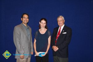 Two men in suits with a young lady who is a scholarship recipient.