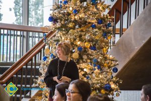 JoAnna Schilling smiling in front of decorated Christmas tree.