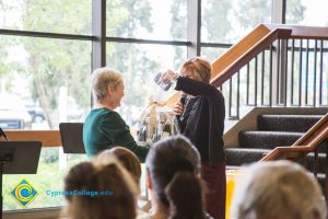 Dr. JoAnna Schilling handing a woman a raffle basket.