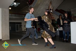 Employees and students dancing, while dressed up for Mardi Gras parade