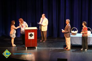 A student being congratulated as she receives her award at the 2014 Scholarship Awards Ceremony.