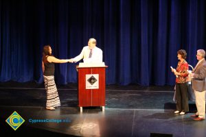 A student being congratulated as she receives her award at the 2014 Scholarship Awards Ceremony.