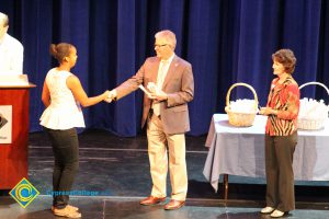 A student being congratulated as she receives her award at the 2014 Scholarship Awards Ceremony.