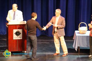 A student being congratulated as he receives his award at the 2014 Scholarship Awards Ceremony.