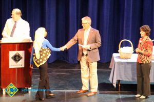 A student being congratulated as she receives her award at the 2014 Scholarship Awards Ceremony.