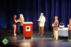 A student being congratulated as she receives her award at the 2014 Scholarship Awards Ceremony.