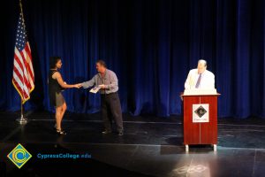 A student being congratulated as she receives her award at the 2014 Scholarship Awards Ceremony.