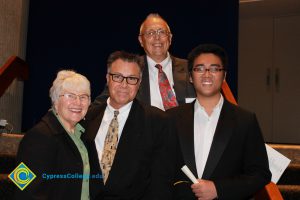 Kay & Mal Bruce with a scholarship recipient and a man in glasses and a black suit.