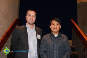 Professor Keith Vescial with a young man in a black checkered dress shirt.