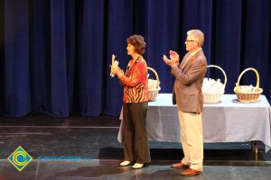 President Bob Simpson and a woman in dark pants and red print shirt applauding at the 2014 Scholarship Awards Ceremony.