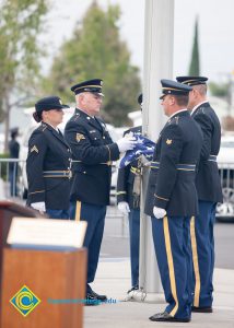 Military personnel folding the American flag.