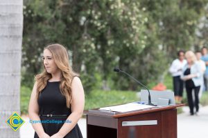 Young lady standing next to podium.