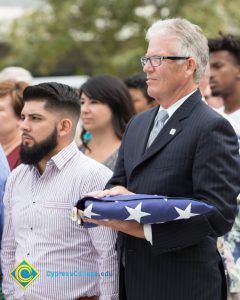 Bob Simpson holding folded American flag.