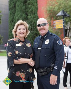 Cypress Police Officer shaking hands with a woman in a black blouse.