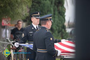 Military personnel folding an American flag for 2016 Veteran's Day Anniversary.