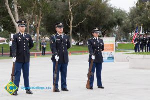 Three military cadets standing with rifles.