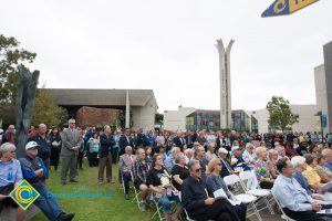 A crowd of people seated on campus.