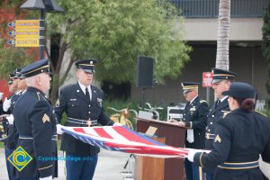 Military personnel folding flag