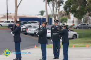 Military personnel in uniform, holding rifles.