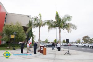 Gary Gopar playing trumpet while flag is lowered.