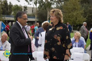 A man and a woman talking in a crowd of guests at the 2016 Veteran's Day Anniversary.