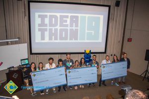 Students holding their prize checks at the Ideathon event.