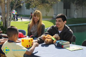 Children playing with large dice at an information table.