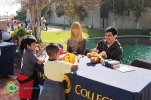 Children playing with large dice at an information table.