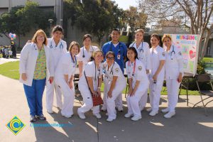 Nursing students in their white scrubs with staff.