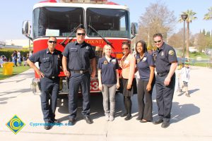 Firefighters standing in front of their fire truck.