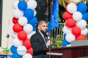 Man with a black beard and a suit speaking at the Veteran's Resource Center Groundbreaking.