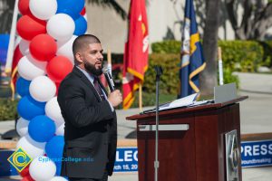 Man with a black beard and a suit speaking at the Veteran's Resource Center Groundbreaking.