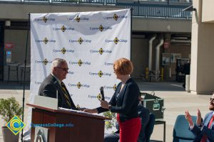 Dr. JoAnna Schilling shakes hands with a man in a suit.