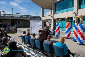 Speaker at VRC Groundbreaking with red, white and blue balloons in the background.