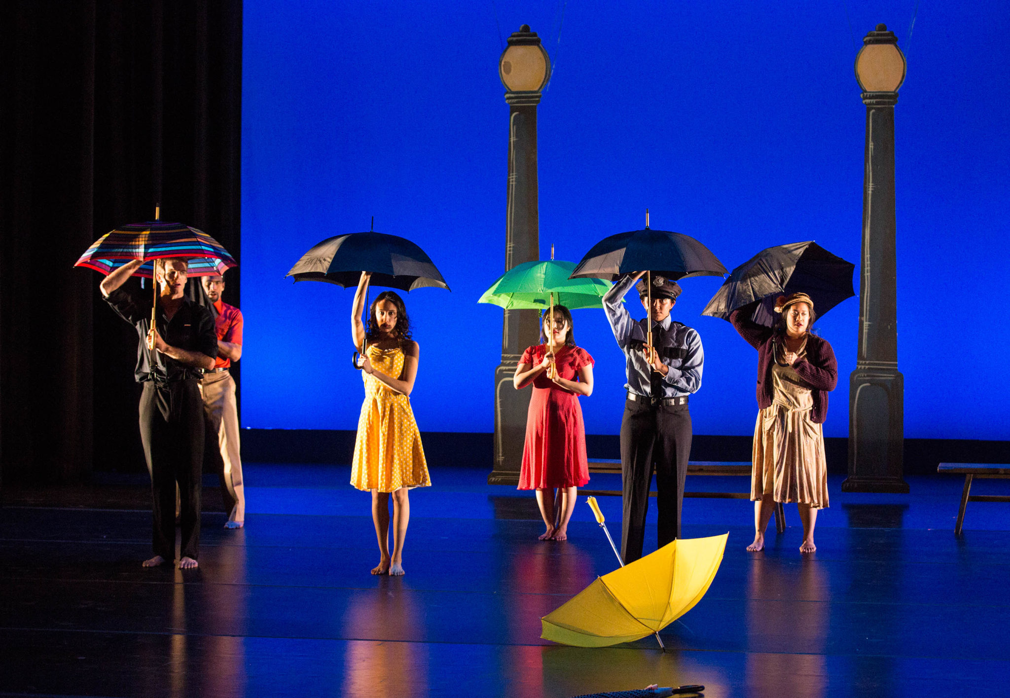 People in Motion dance performers holding opened umbrellas.