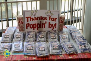 Thanks for Poppin' by! sign with bags of microwave popcorn.