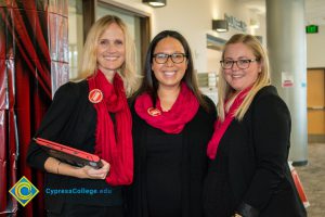 Three women in black with red scarves.