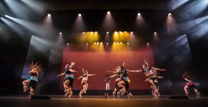 Dancers on stage wearing Native American costumes