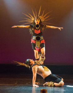 Dancers on stage wearing Native American costumes