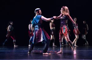 Dancers on stage wearing red and black costumes