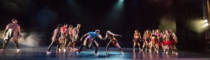 Dancers on stage wearing red and black costumes