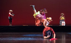 Dancers on stage wearing western costumes