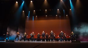 Dancers on stage wearing black costumes