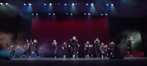 Dancers on stage wearing black costumes