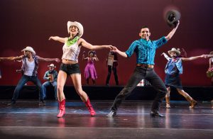 Dancers on stage wearing western costumes