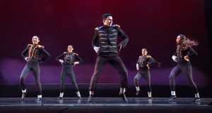 Dancers on stage wearing black costumes