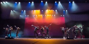 Dancers on stage wearing black costumes