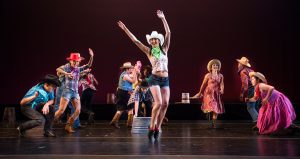 Dancers on stage wearing western costumes